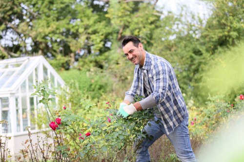 Gardener trimming a small front hedge in Lambeth terrace garden